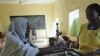 An elderly Southern Sudanese woman casts her vote Monday in a ballot box at a polling center in the city of Um Durman, Sudan, Jan. 10, 2011