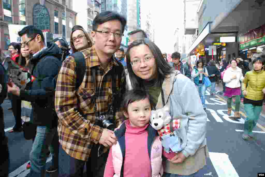 父母帶著女兒參與遊行,女兒手持模仿「路福西」的公仔