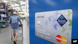Seorang konsumen berjalan melewati iklan kartu MasterCard di toko Sam's Club di Bentonville, Ark., 4 Juni 2015.