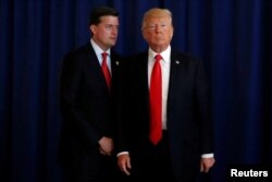 FILE - White House Staff Secretary Rob Porter (L) reminds U.S. President Donald Trump he had a bill to sign after he departed quickly following remarks at his golf estate in Bedminster, New Jersey U.S., Aug.12, 2017.