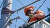 FILE - A worker installs fiber optic cable to bring broadband internet service to a rural area near Belfair, Wash., Aug. 4, 2021.
