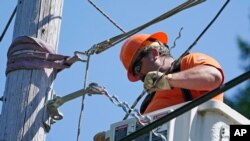 FILE - A worker installs fiber optic cable to bring broadband internet service to a rural area near Belfair, Wash., Aug. 4, 2021.