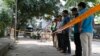FILE - Bangladeshi police and detectives stand by the site where Italian citizen Cesare Tavella was gunned down by unidentified assailants in Dhaka, Sept. 29, 2015. Islamic State has claimed responsibility for the killing.