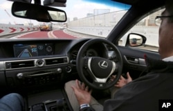 FILE - An employee of Toyota Motor Corp., drives automated driving test vehicle during a test drive of Toyota's self-driving technologies in Tokyo. Such cars are one field in which researchers are seeking to expand the limits of machine learning.