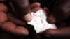FILE - A Congolese mineral trader holds a piece of paper containing nuggets of gold in a mud hut at Numbi in eastern Congo, July 24, 2010.