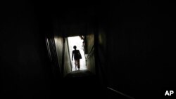 In this March 11, 2017 photo, Tin, a Christian Burmese refugee, leaves a school after dropping off her children in Kuala Lumpur, Malaysia. Tin is a Christian Burmese who fled Myanmar and is hoping to resettle in the United States.