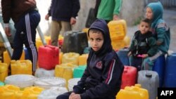 Sejumlah anak-anak Palestina tampak mengantre untuk mendapatkan air di wilayah Zaytoun, Jalur Gaza, pada 31 Maret 2024, di tengah berkecamuknya perang antara Israel dan Hamas. (Foto: AFP)