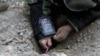 FILE - An Afghan Army soldier searches for land mines with a metal detector during an exercise on defusing improvised explosive devices in Jalalabad, east of Kabul, Afghanistan.