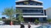 FILE - People walk past the Nalia Radio and Television (NRT) building in Sulaimaniyah city, in the Kurdish autonomous region of northern Iraq, Aug. 22, 2020.