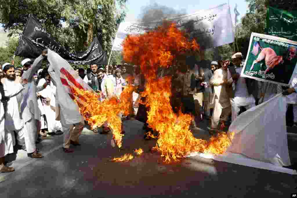 Afghan university students burn a U.S. flag in the Surkhrod district of Nangarhar province, Afghanistan, September 19, 2012.