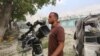 FILE - Somali Freelance journalist Mohamed Guray holds on to his camera after he was injured in a secondary explosion in front of Dayah hotel in Somalia's capital Mogadishu, Jan. 25, 2017.
