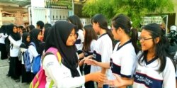 Siswa-siswi SD Kristen Petra Jombang menyalami siswa-siswi Madrasah Ibtidaiyah (MI) Islamiyyah-Plosogenuk yang mengunjungi sekolah mereka (Foto:VOA/Petrus Riski).