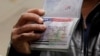 FILE - A Yemeni national who was denied entry into the U.S. shows a canceled visa in his passport, at Washington Dulles International Airport, in Dulles, Virginia, Feb. 6, 2017.