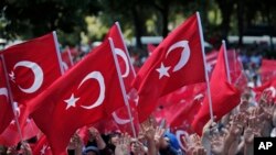 支持政府的民众手举土耳其国旗举行游行