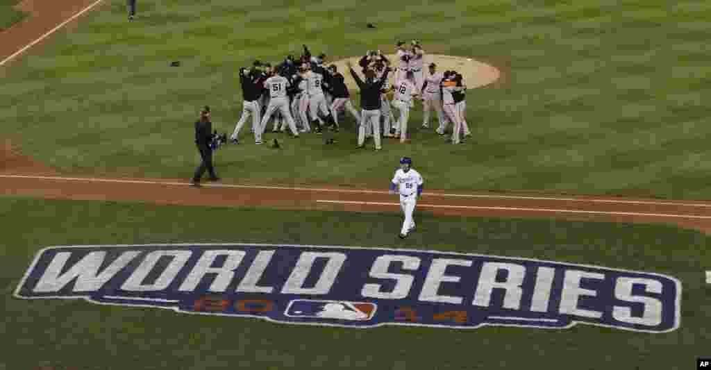 The San Francisco Giants celebrate their 3-2 win after Game 7 of baseball's World Series against the Kansas City Royals, Kansas City, Missouri, Oct. 29, 2014.