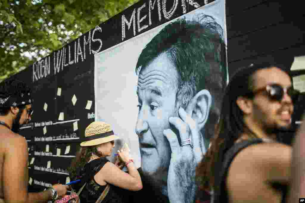 Festival goers pay tribute to the late actor Robin Williams at a makeshift memorial at the 22nd Sziget (Island) Festival on the Shipyard Island in northern Budapest, Hungary, Aug. 13, 2014.