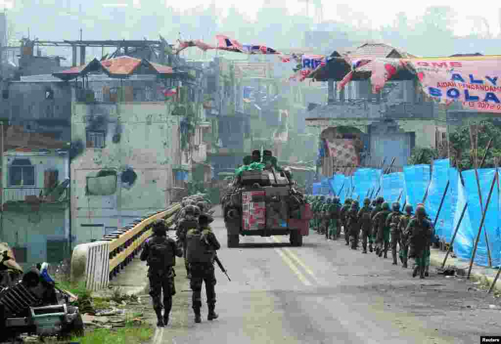A personnel carrier flanked by government troops head toward Mapandi bridge after 100 days of intense fighting between soldiers and insurgents from the Maute group, who have taken over parts of Marawi, Philippines, Aug. 30, 2017.
