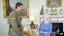 Britain's Queen Elizabeth II greets Corp. Ben Robert-Smith, from Australia, who was recently awarded the Victoria Cross, during an audience at Buckingham Palace in London, Nov.15, 2011. 