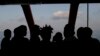 Rescued migrants are silhouetted as they look out at the horizon aboard the Ocean Viking, in the Mediterranean Sea, Sept. 13, 2019.