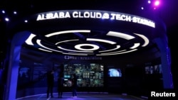 FILE - Visitors stand inside a booth introducing Alibaba Cloud services at an exhibition venue during Alibaba Group's 11.11 Singles' Day global shopping festival in Shenzhen, China, Nov. 11, 2016. 