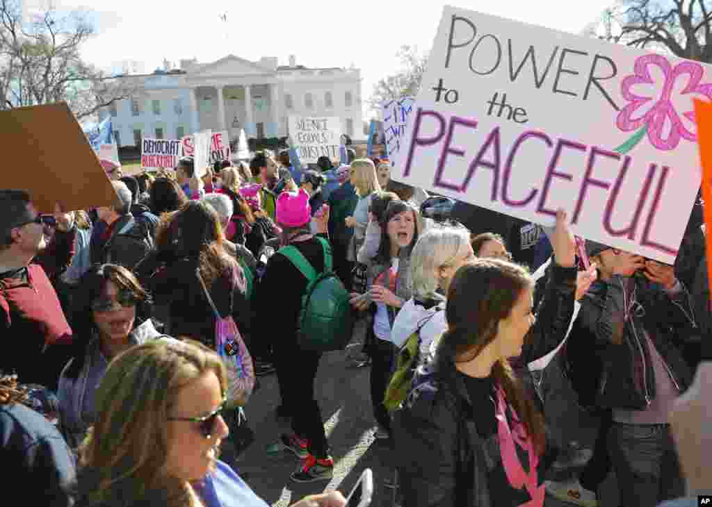 Women's March demonstrators walk past the White House in Washington, Jan. 20, 2018.