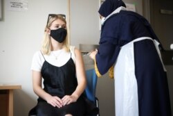 A person receives a dose of the Pfizer BioNTech vaccine at the Central Middlesex Hospital in London, Aug. 1, 2021.