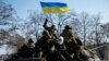 Members of the Ukrainian armed forces ride on an armored personnel carrier near Debaltseve after the signing of a cease-fire agreement in Minsk, Feb. 12, 2015.