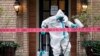 Seorang petugas CG Environmental HazMat mensterilkan pintu masuk ke kediaman seorang anggota tim medis di RS 'Texas Health Presbyterian' yang telah terdampak virus Ebola di Dallas, Texas, 12 Oktober 2014. (Foto: dok).