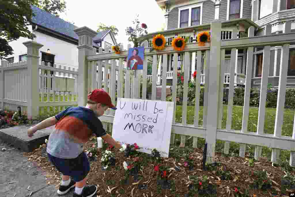 Seorang bocah meletakkan karangan bunga di depan rumah lokasi syuting 'Mork & Mindy' di Boulder, Colorado (11/8).