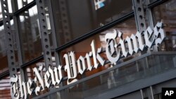 FILE - A sign for The New York Times hangs above the entrance to its building, May 6, 2021, in New York.