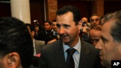 Syrian President Bashar al-Assad, center, after at the end of the second day closing session of the Arab League Summit in Sirte, Libya, (file photo)