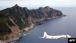 FILE - A Japanese Maritime Self-Defense Force plane flying over the disputed islets known as the Senkaku islands in Japan and Diaoyu islands in China, in the East China Sea. 