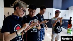 Para pemain di Hong Kong berlomba di seluruh kota itu dalam kompetisi “PokeGame” yang pertama di dunia, Sabtu (6/8).