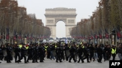Polisi anti huru-hara Perancis menghadang para demonstran berjaket kuning (gilets jaunes) yang berunjuk rasa memprotes kenaikan harga BBM di Champs-Elysees, Paris, 15 Desember 2018. (Foto: dok).