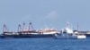 This handout video grab taken on April 27, 2021, and received from the Philippine Coast Guard on May 5, 2021, shows the Philippine Coast Guard ship BRP Cabra (front) monitoring Chinese vessels at Sabina Shoal, a South China Sea outcrop claimed by Manila.