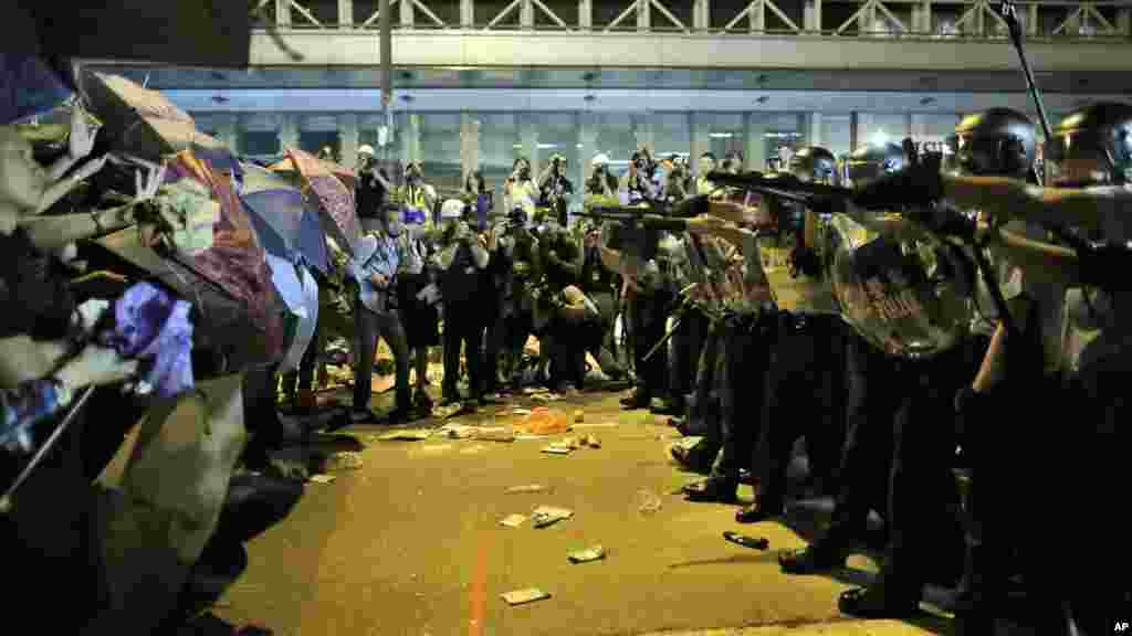 Riot police officers try to stop protesters from moving forward on a pro-democracy protest encampment in the Mong Kok district of Hong Kong early, Oct. 19, 2014.