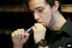Matt Alfonso dari Avail Vapor mencoba salah satu rokok elektrik di Richmond, Amerika Serikat, 15 April 2014.