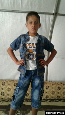 Khaled berpose untuk diambil gambarnya oleh oleh ibunya di dalam tenda di kamp pengungsian untuk anak yatim piatu di daerah pinggiran Idlib.