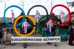 Warga Tibet yang diasingkan di Dharmsala, India, menggunakan lambang Cincin Olimpiade sebagai penyangga saat mereka menggelar aksi protes terhadap penyelenggaraan Olimpiade Musim Dingin 2022 di Beijing, Rabu, 3 Februari 2021..