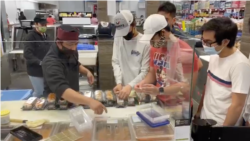 Nur Cholis (kiri) bersama anak-anak muda anggota IMAAM Center memberi label pada 100 kotak sushi (dok: Nur Cholis/IMAAM Center)