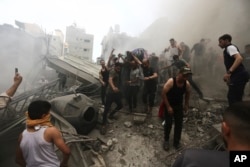 Warga Palestina mengeluarkan jenazah dari reruntuhan bangunan pasca serangan udara Israel di kamp pengungsi Jebaliya, Jalur Gaza, Senin, 9 Oktober 2023. (Foto: AP)