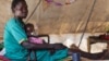 A woman carries her severely malnourished child at a clinic in Doro refugee camp in South Sudan, March 9, 2012.