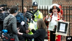 Tony Appleton, a town crier, announces to the assembled media the birth of the royal baby, outside the Lindo Wing, St. Mary's Hospital, London, Saturday, May 2, 2015.