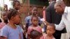 FILE - A health care worker checking for Ebola signs takes the temperatures of children before they enter their school in Conakry, Guinea, Jan. 19, 2015.