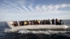 FILE - Migrants, who tried to flee to Europe, travel in a dinghy after they were stopped by Libyan coast guards and made to head to Tripoli, Sept. 29, 2015. The North African country has turned into a major hub for human traffickers smuggling African migrants by boat to Italy, with the Libyan coastguard under pressure from Europe to stem the flow. 