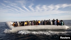 FILE - Migrants, who tried to flee to Europe, travel in a dinghy after they were stopped by Libyan coast guards and made to head to Tripoli.