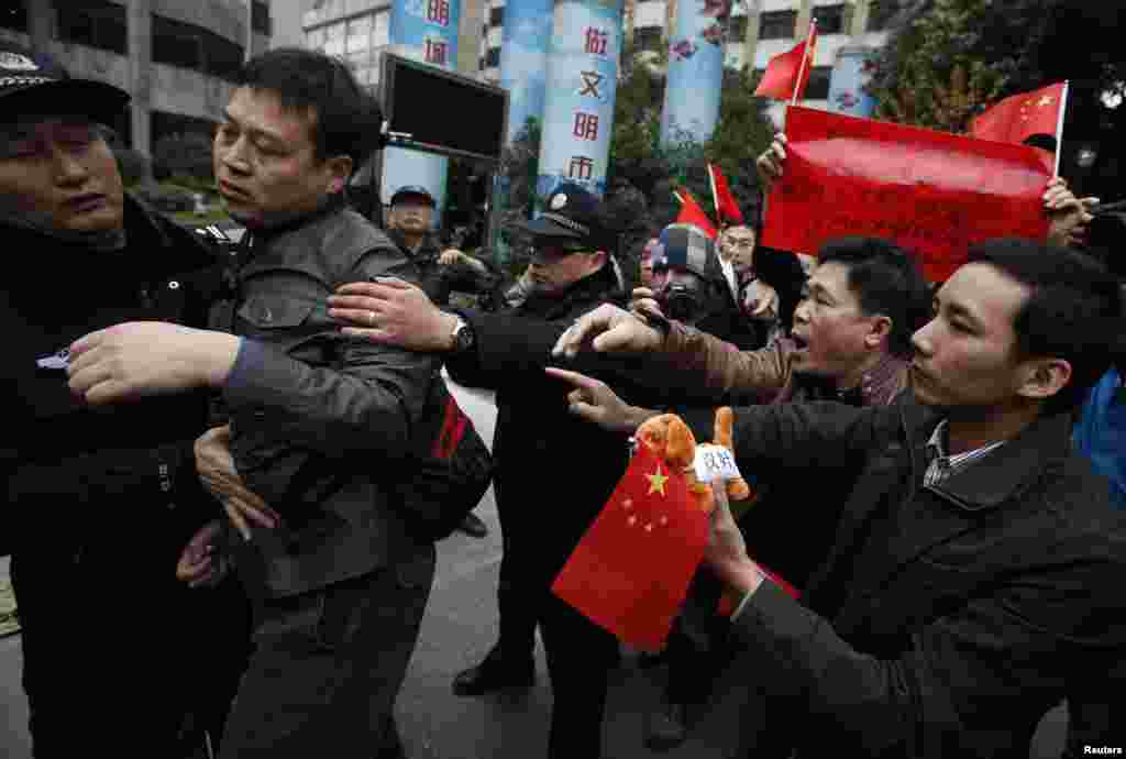2013年1月9日,警察在广州《南方周末》总部外面将支持《南周》的抗议者和同他们冲突的左派人士分隔开来。