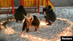 Para pendukung oposisi Rusia,Alexei Navalny, yang dipenjara karena pelanggaran pembebasan bersyarat, menyusun lilin berbentuk hati dalam demo pada hari Valentine, di Omsk, Rusia, 14 Februari 2021.