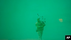 Kopral Muda Jamie Killorn dari 4SCOTS The Highlanders Company memainkan alat musik bagpipe di akhir latihan Steadfast Dart 2025, yang melibatkan 10.000 pasukan anggota NATO, di lapangan latihan di Smardan, Rumania timur, pada 19 februari 2025. (Foto: AP/Vadim Ghirda)