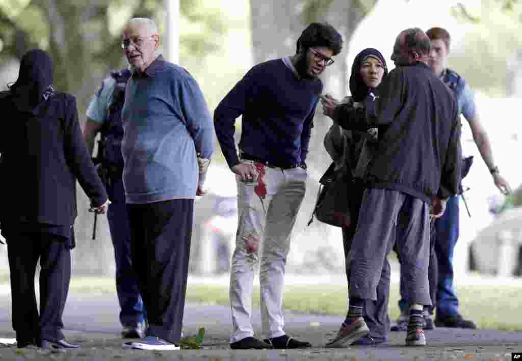 People stand across the road from a mosque in central Christchurch, New Zealand, March 15, 2019.